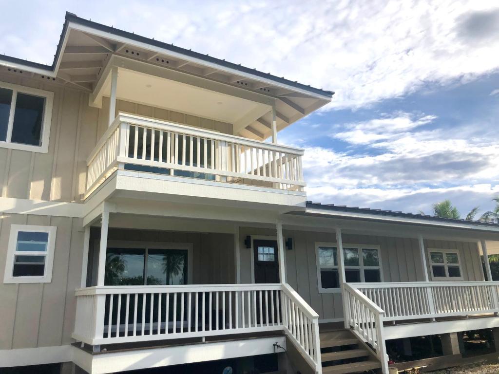 a house with a porch and a balcony at Mākaha House in Waianae
