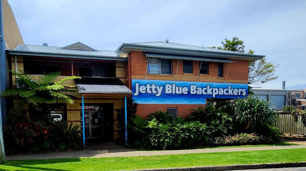 ein blaues Gebäude mit einem blauen Schild darauf in der Unterkunft Jetty Blue Backpackers in Coffs Harbour