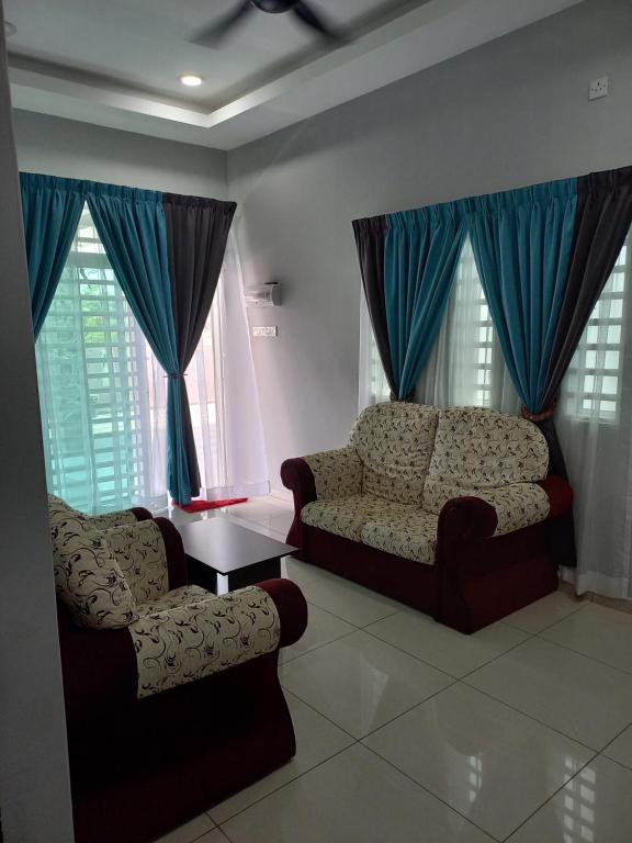 a living room with two chairs and a table at Yaths homestay in Butterworth