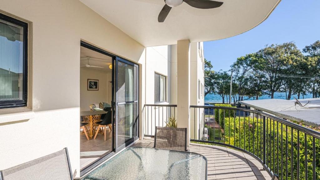 a balcony with a glass table and a view of the ocean at Quiet location across from waterfront - South Esp, Bongaree in Bongaree