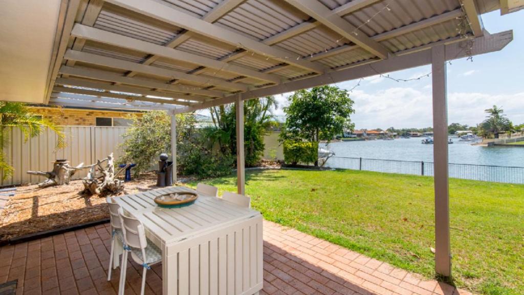 a patio with a table and chairs and a view of the water at Lowset home on the canal - Dolphin Dr, Bongaree in Bongaree