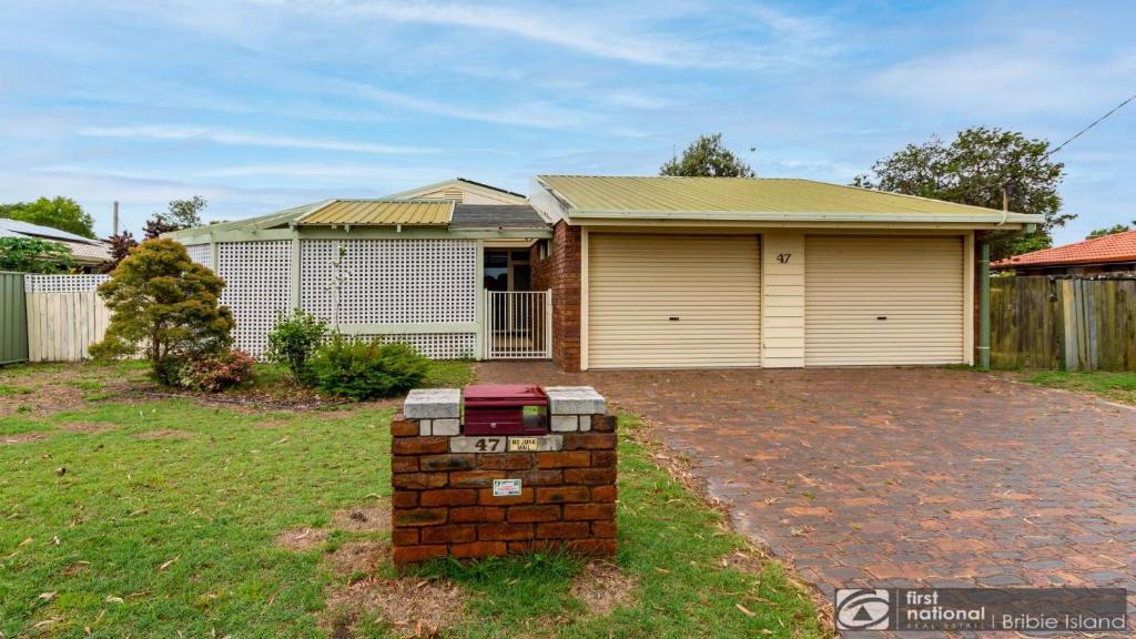 a house with a brick pillar in front of a yard at Banksia Gem One Street Back From Waterfront in Banksia Beach