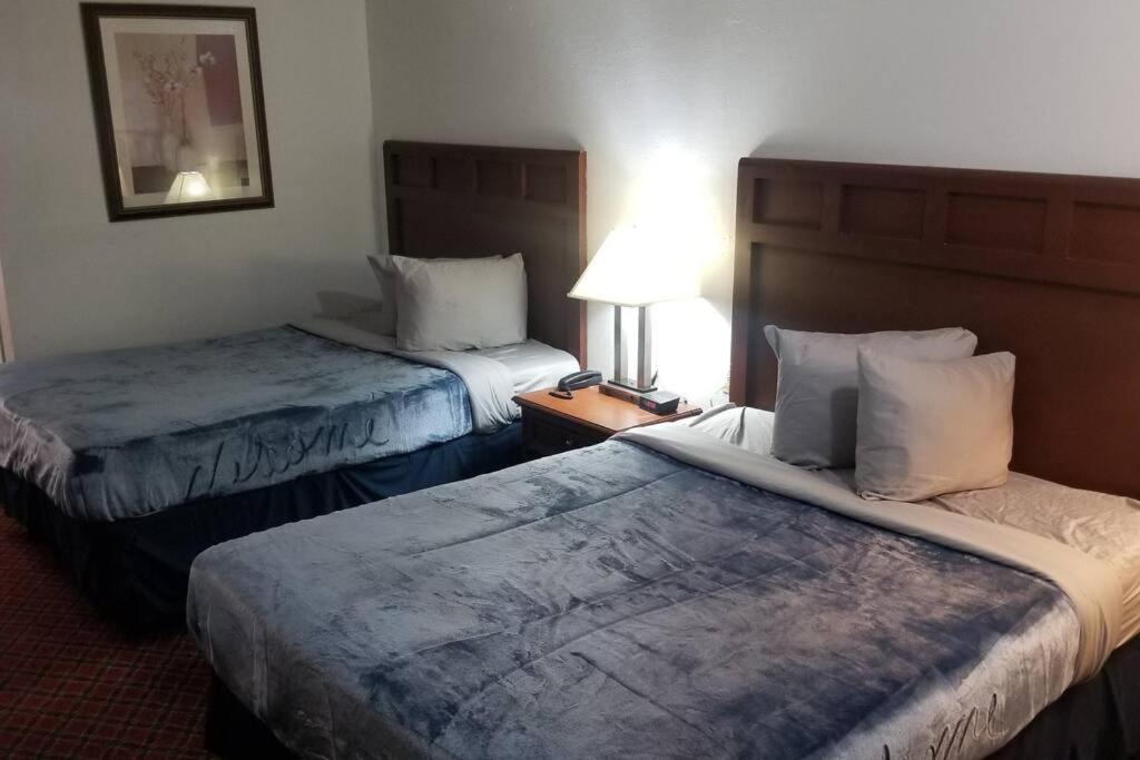 ein Hotelzimmer mit 2 Betten und einer Lampe in der Unterkunft OSU 2 Queen Beds Hotel Room 125 Booking in Stillwater