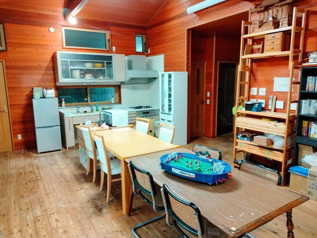 cocina con mesa y sillas en una habitación en 木の家ゲストハウス, en Mito