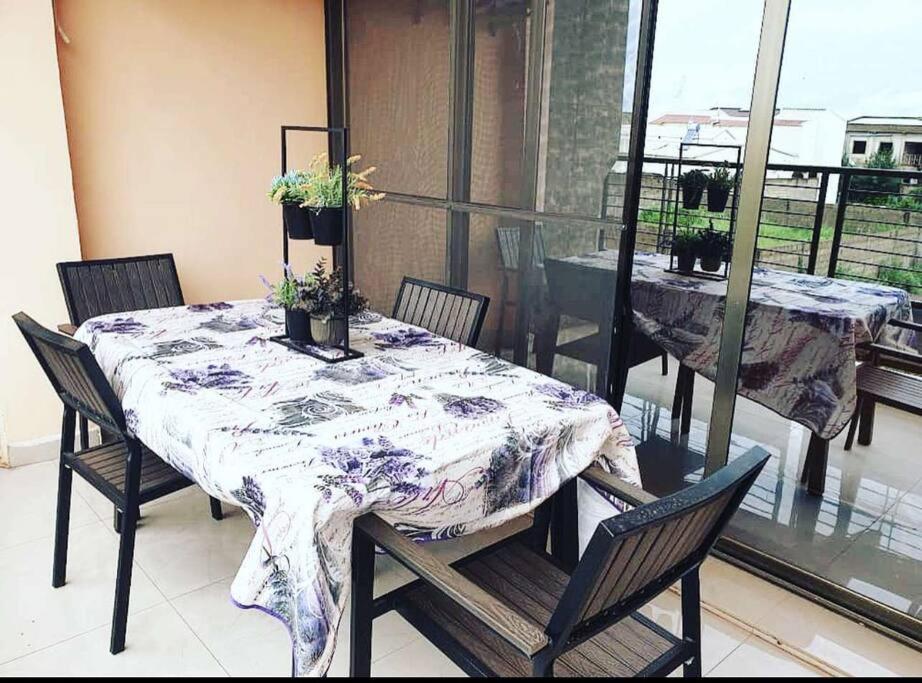 d'une table avec des chaises et un chiffon de table sur un balcon dans l'établissement Appartement luxueux ouaga2000(2 chambres ), à Ouagadougou