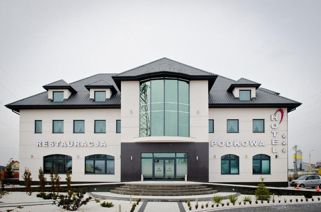 a large white building with a black roof at Hotel Podkowa in Płock