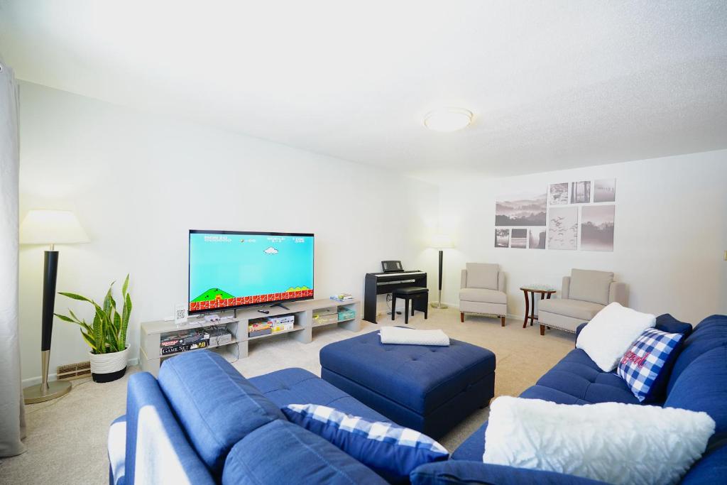 sala de estar con sofás azules y TV de pantalla plana en Blue House en Sioux Falls