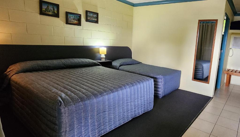 Habitación de hotel con 2 camas y espejo en Nanango Antler Motel, en Nanango