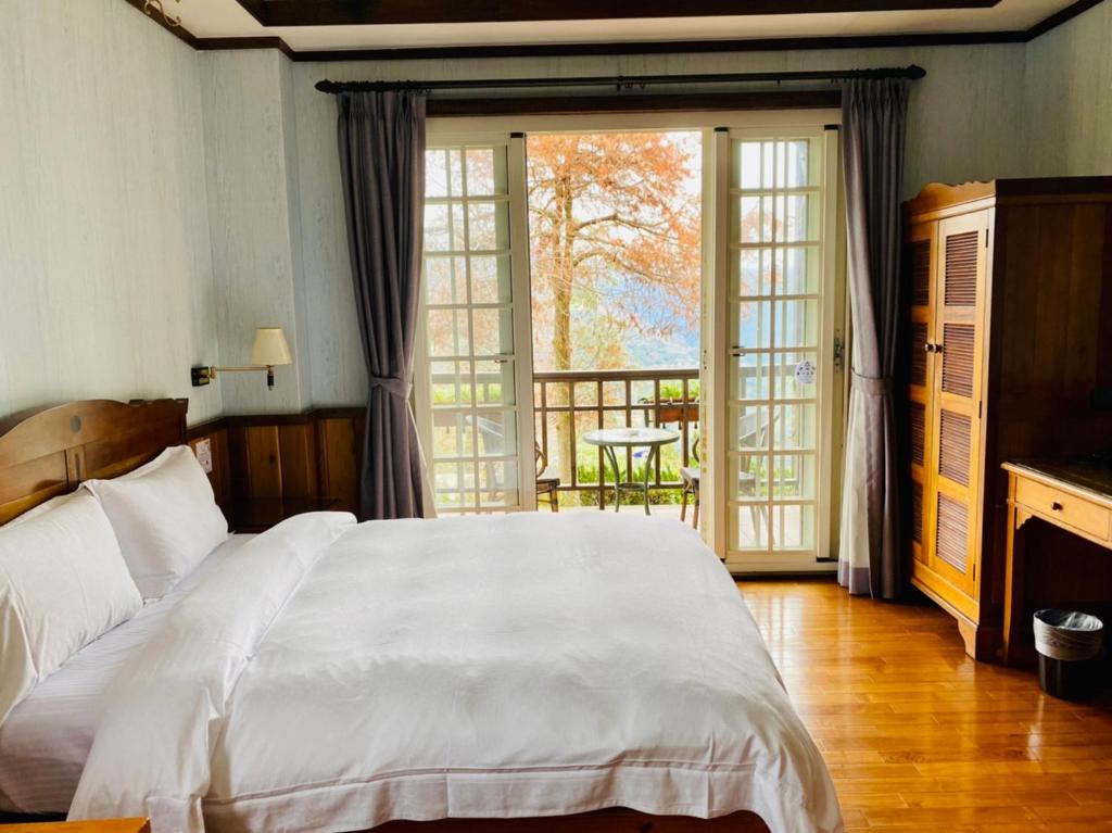 a bedroom with a white bed and a balcony at 見晴花園山莊Sunshine Villa in Ren&#39;ai