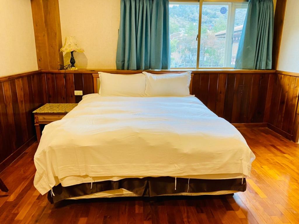 a large white bed in a room with a window at 見晴花園山莊Sunshine Villa in Ren&#39;ai