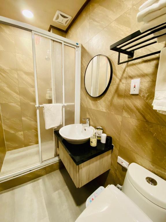 a bathroom with a sink and a toilet and a mirror at 見晴花園山莊Sunshine Villa in Ren&#39;ai
