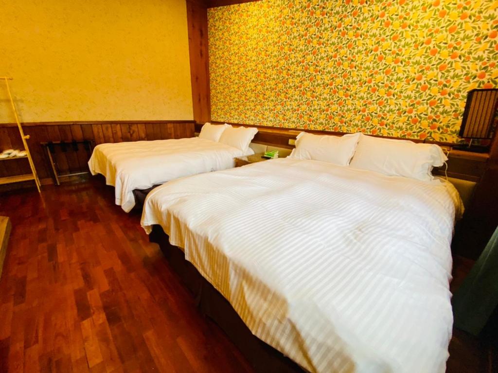 two beds in a hotel room with white sheets at 見晴花園山莊Sunshine Villa in Ren&#39;ai