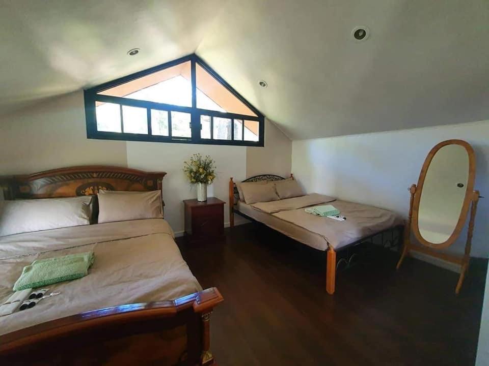 a bedroom with two beds and a window at 2BR- 4th Floor Camp John hay For Rent in Baguio