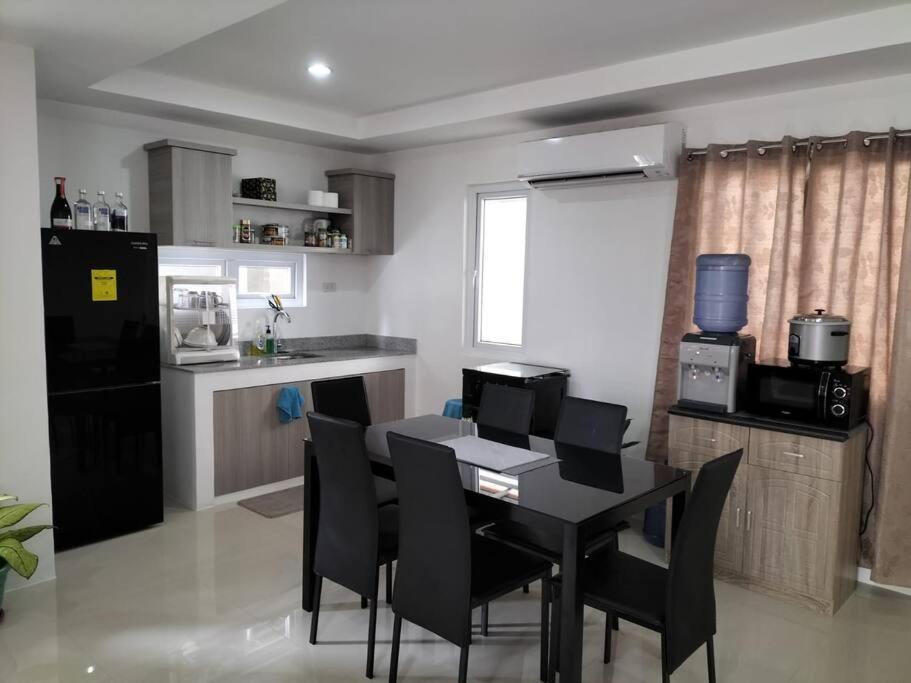 a kitchen with a black table and black chairs at House in Philippines in Liloan