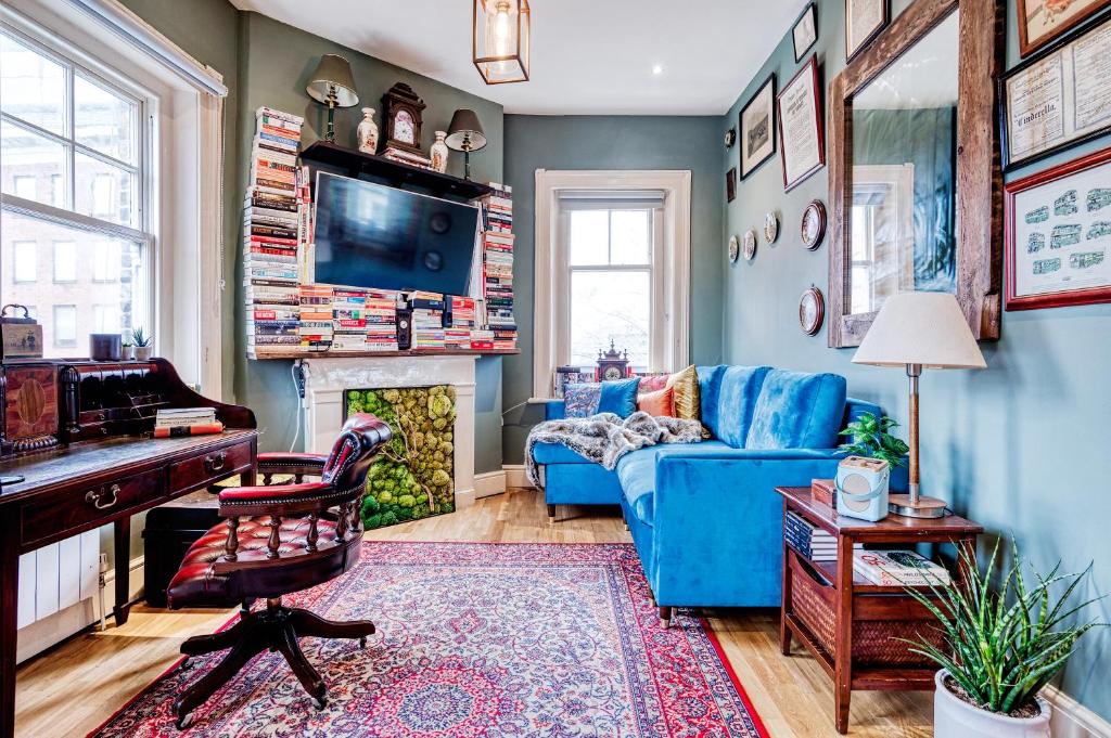 a living room with a blue couch and a piano at Sunny Corner Apartment in Center of London in London