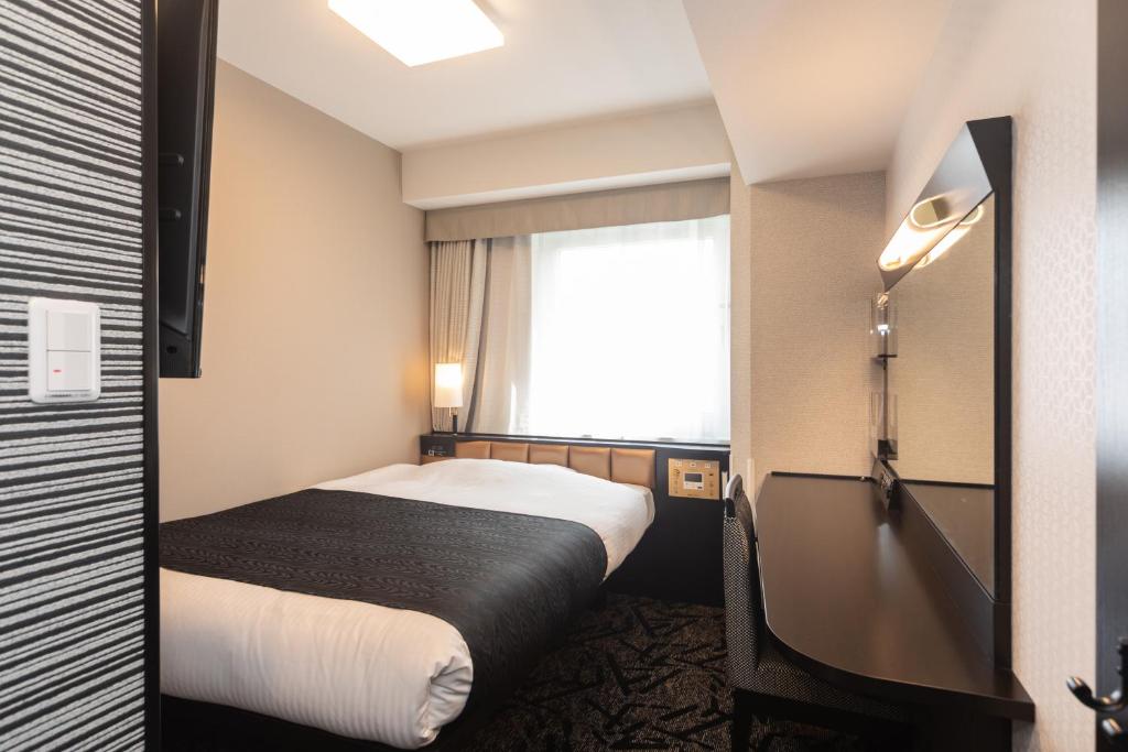 Postel nebo postele na pokoji v ubytování APA Hotel Namba Shinsaibashi Higashi
