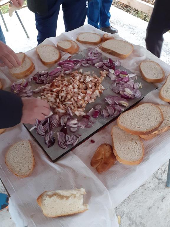 a table with a tray of bread and onions on it at Cazare REGIM HÔTELIER ZĂRNEŞTI in Zărneşti