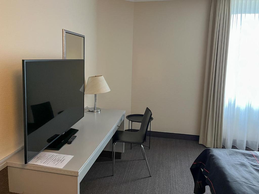 TV a/nebo společenská místnost v ubytování DORMERO Hotel Dessau-Roßlau