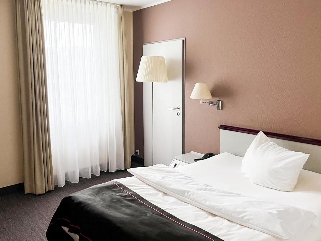 Postel nebo postele na pokoji v ubytování DORMERO Hotel Dessau-Roßlau