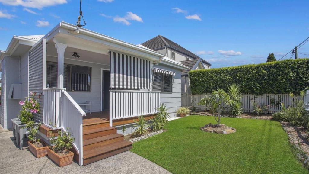 a house with a wooden staircase in a yard at Coast Along - Ettalong Beach in Ettalong Beach