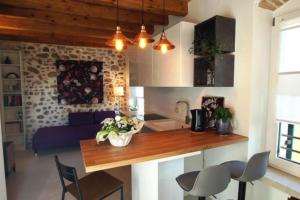 cocina y sala de estar con mesa y sillas en Sui Tetti di Valeggio - Holiday Apartment en Valeggio sul Mincio