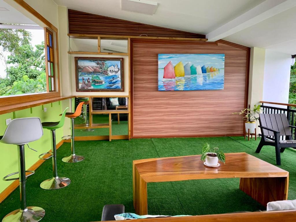 邦勞的住宿－SUNSHINE STAY PANGLAO，客厅配有桌子和绿色地毯