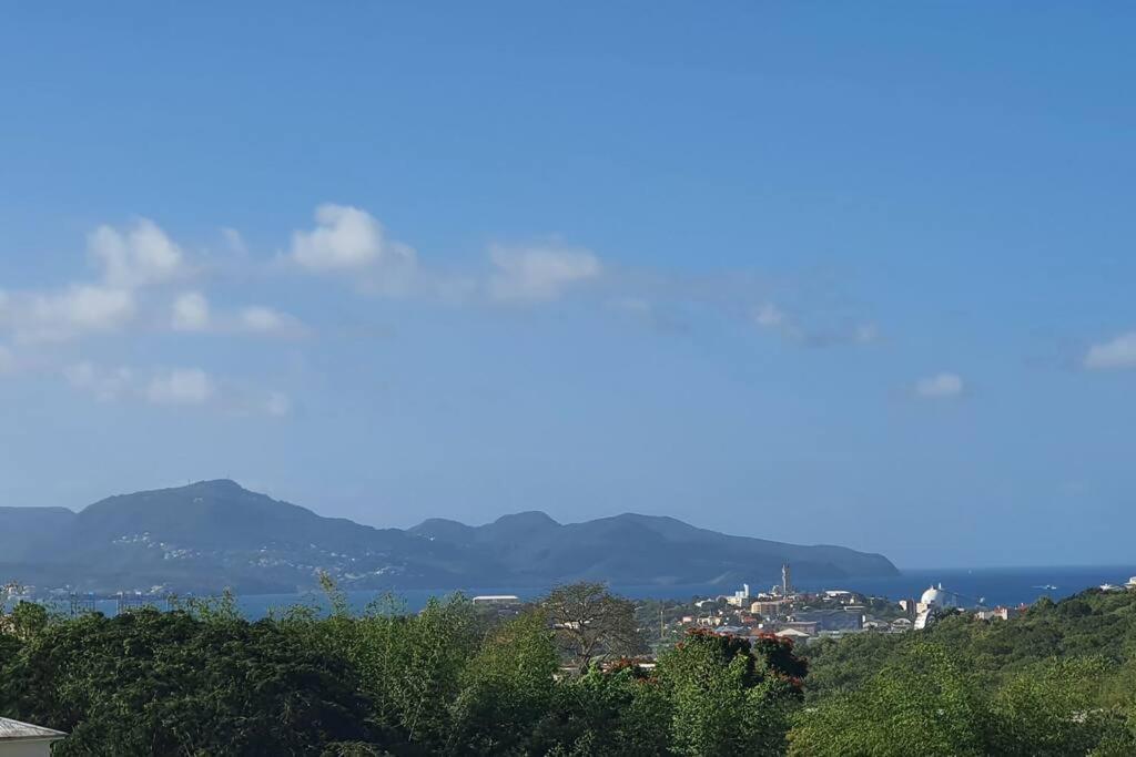 a view of a city with mountains in the distance at Appt Hadayali - vue mer - proche CHU in Fort-de-France