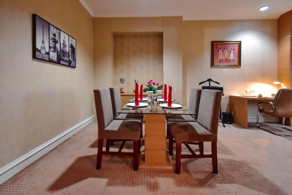a dining room with a table and chairs with red candles at Surabaya Suites Hotel Powered by Archipelago in Surabaya