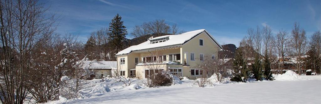 una casa è coperta di neve in un cortile di Chalet Manhard a Pfronten