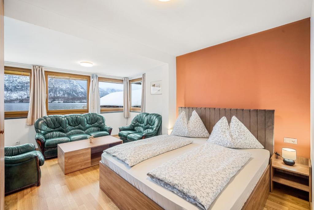 - une chambre avec un lit et deux chaises vertes dans l'établissement Hallstatt Lakeside Top 2 - Zimmer mit Gartenzugang, à Hallstatt