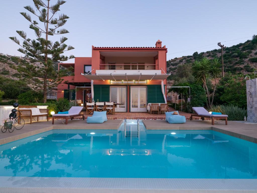 a house with a swimming pool in front of a house at Villa Verde in Malia