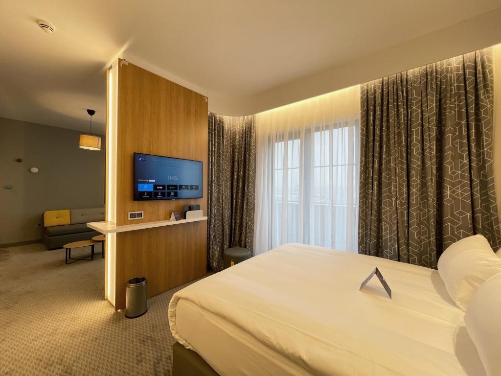 a hotel room with a bed and a flat screen tv at Holiday Inn Express - Ankara - Airport by IHG in Ankara