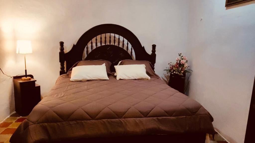 um quarto com uma cama grande e 2 almofadas em Casa Adiel em Campeche