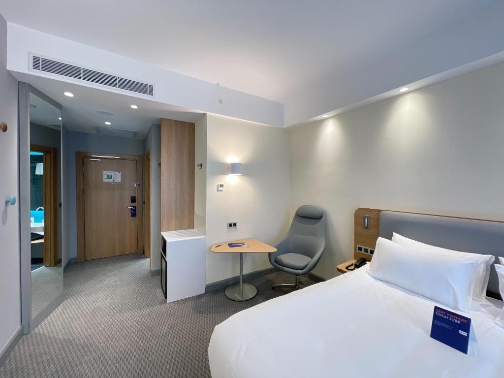 a hotel room with a bed and a desk at Holiday Inn Express - Ankara - Airport by IHG in Ankara