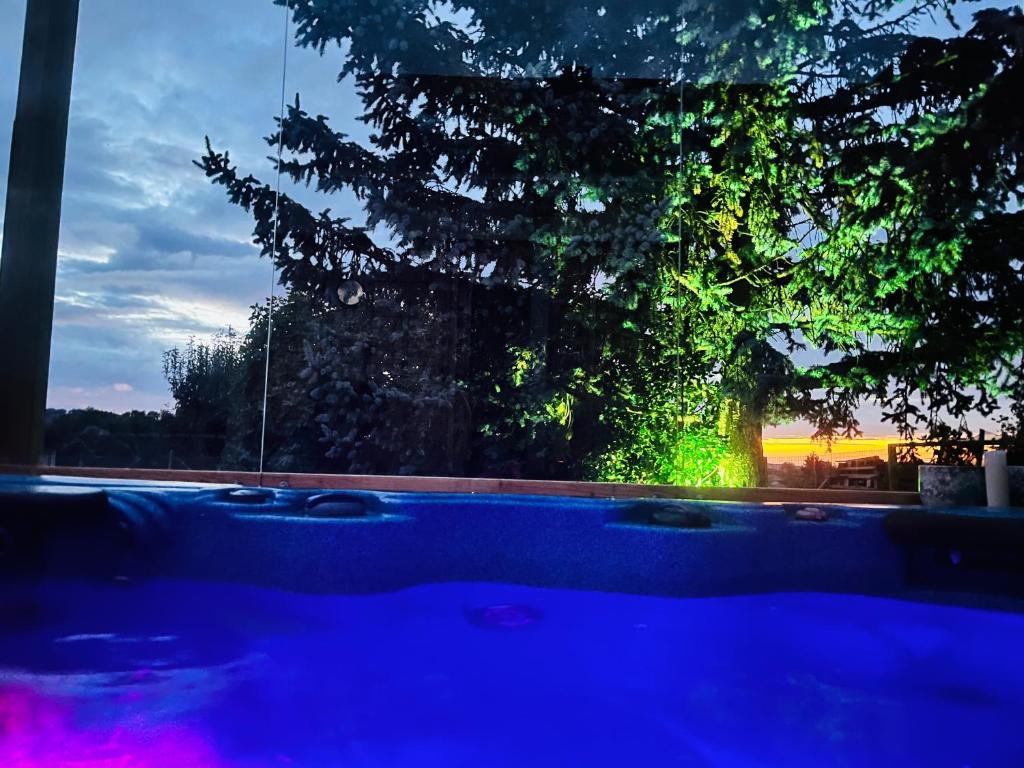 a night view of a tree and a pool at Spa La k abane in Blandin