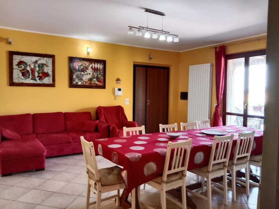 sala de estar con sofá rojo, mesa y sillas en Il giglio perlato, en Marsciano