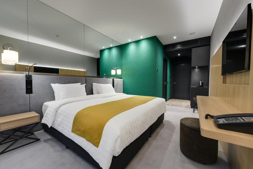 um quarto com uma cama grande e uma parede verde em Glarros OldTown em Tbilisi