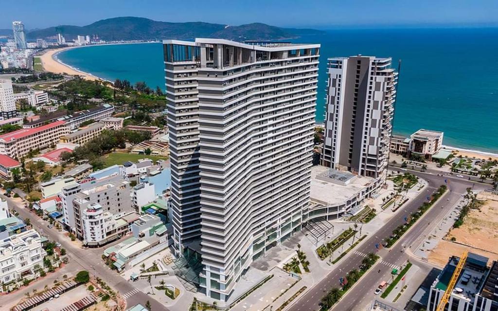 een luchtzicht op een groot wit gebouw naast een strand bij Glese Balcony Seaview Apartment - FLC Sea Tower Quy Nhon in Quy Nhon