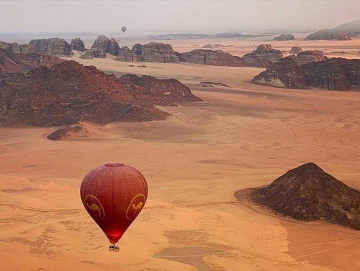 a hot air balloon is flying over the desert at Flower Life Camp in Wadi Rum