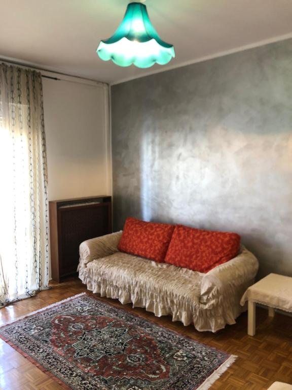 een woonkamer met een bank met rode kussens erop bij lacasettadiAlice in Cerro Maggiore