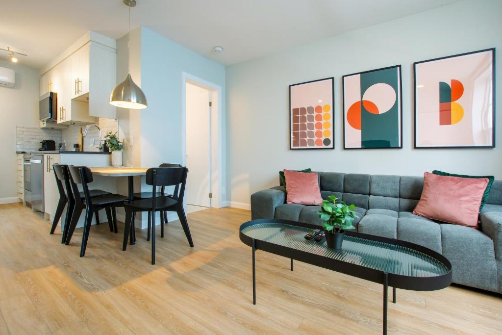 a living room with a couch and a table at Appart Hôtel Le Saint-Anselme - Par Revenus Locatifs Qc in Quebec City