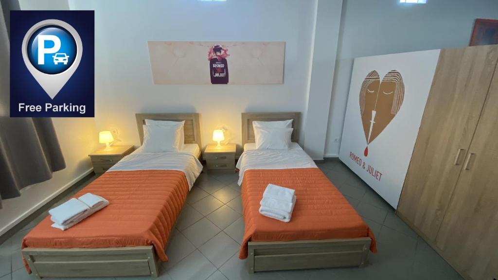 two beds with orange sheets in a room at Patras Juliet House in Patra