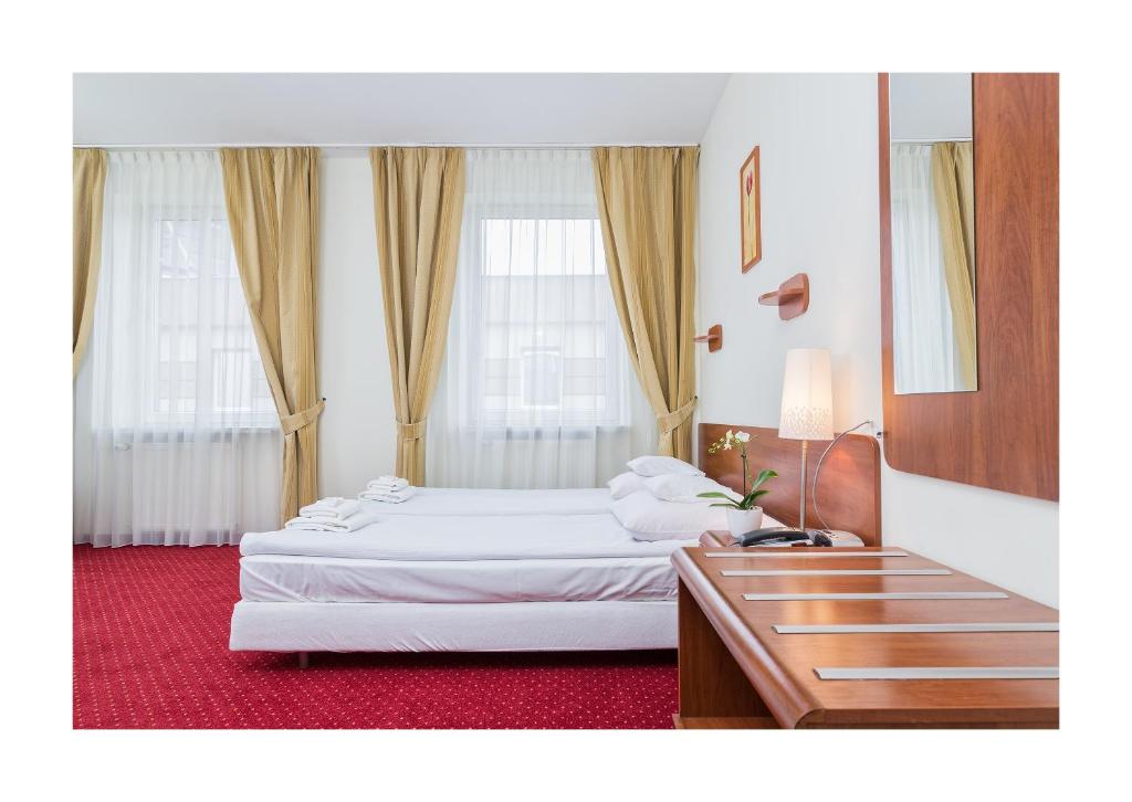 a hotel room with two beds and a table at Hotel Colibra in Warsaw