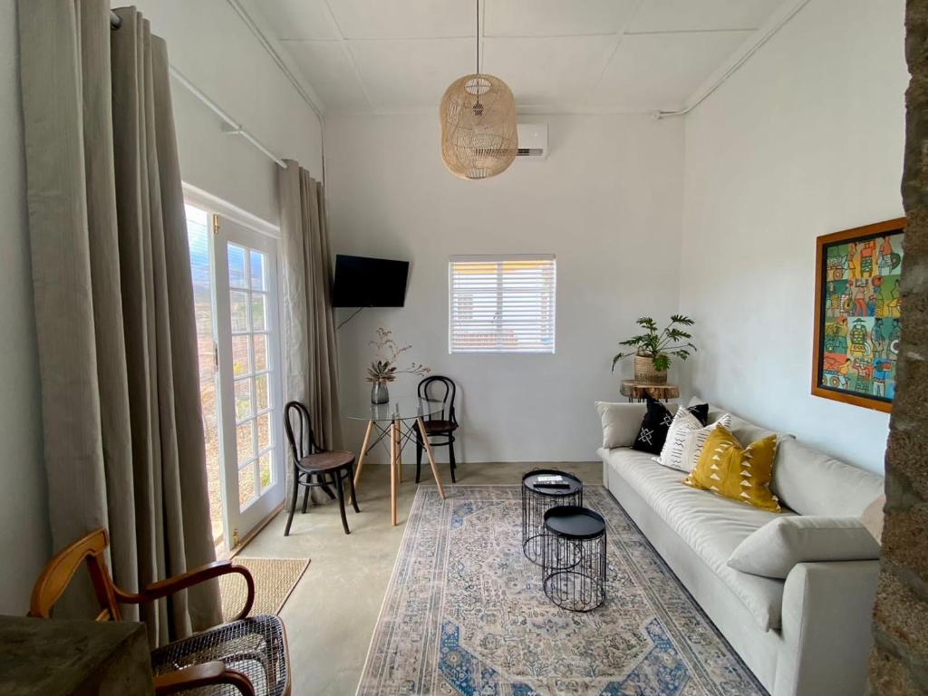 a living room with a white couch and a table at vanwyksdorp accommodation - OLDE POST HOUSE in Van Wyksdorp