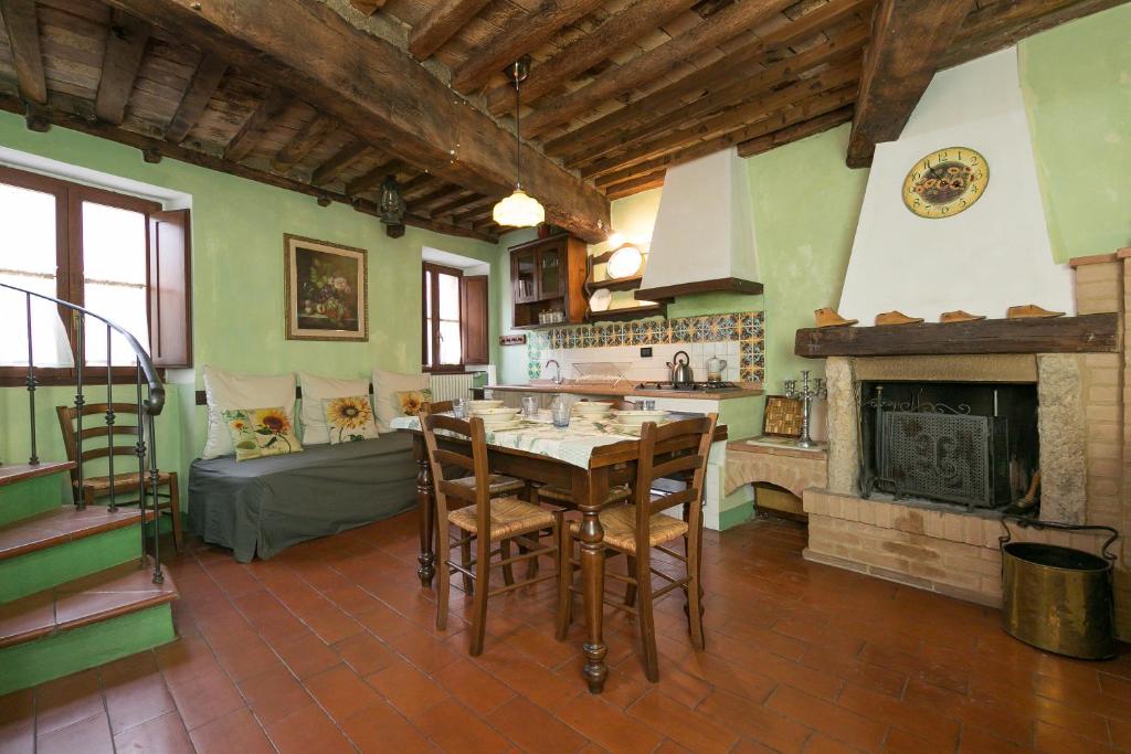 a kitchen with a table and chairs and a fireplace at Il Mirtillo in Pisa