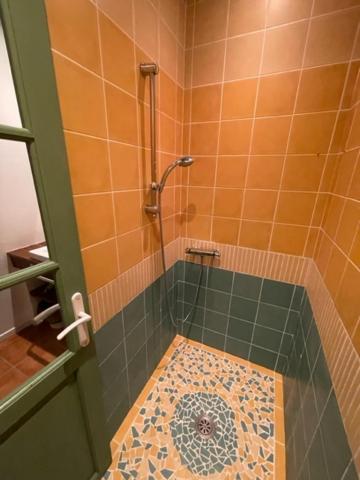 ein Bad mit einer Dusche und Fliesenboden in der Unterkunft Lauraguel Gîte in Mourvilles-Hautes