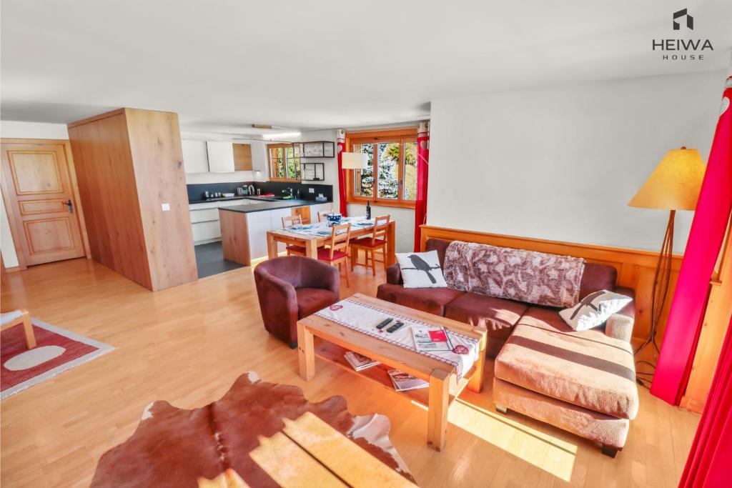 ein Wohnzimmer mit einem Sofa und einem Tisch in der Unterkunft Logement spacieux et confortable in Chateau-d'Oex