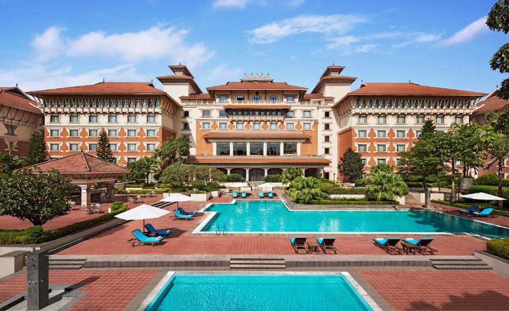 a large building with a pool in front of it at Hyatt Regency Kathmandu in Kathmandu