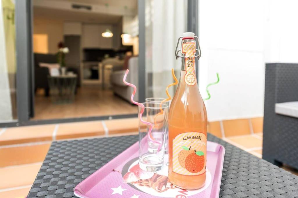 a bottle and a glass on a pink tray at Apartamento con jardin privado y portero (A) in Madrid