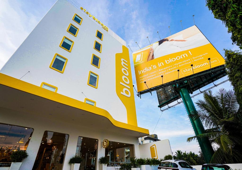 a yellow and white building with a sign on it at Bloom Hotel - Bengaluru Airport in Devanhalli